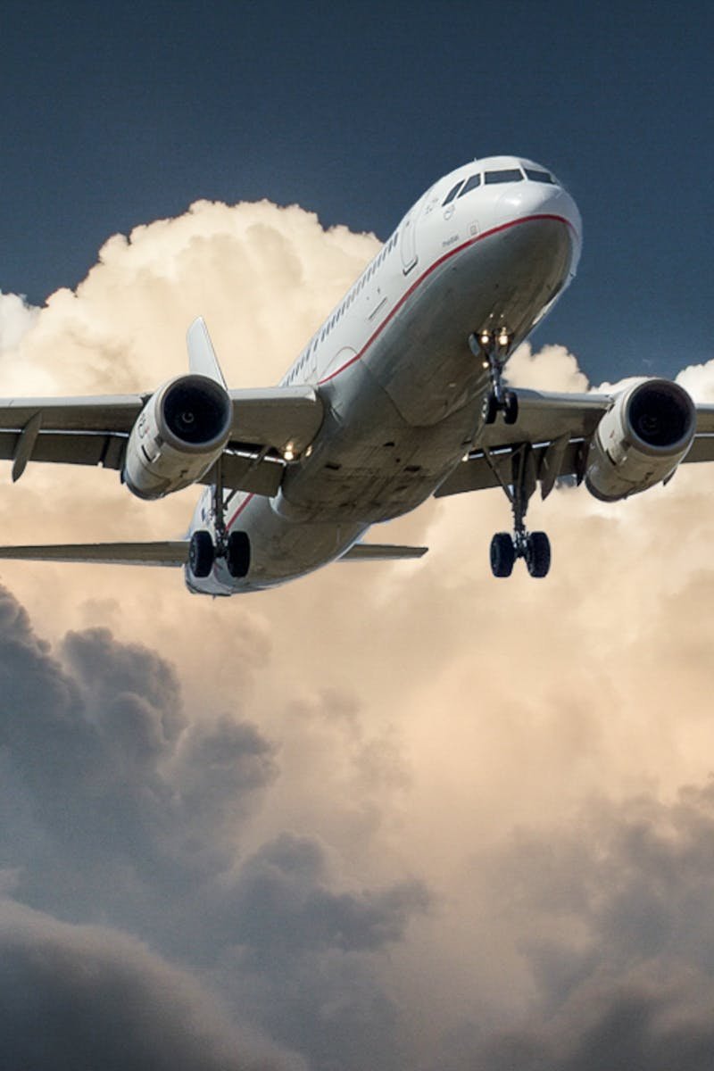 A commercial airplane flying through dramatic clouds, showcasing aviation in action.